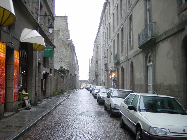 Une rue du vieux St Malo, on voit les remparts et une porte au fond (Porte St Louis?)