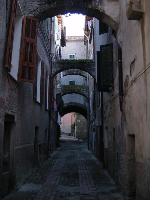 Many little archs keeping houses together, a small street of Isolabona, Italy