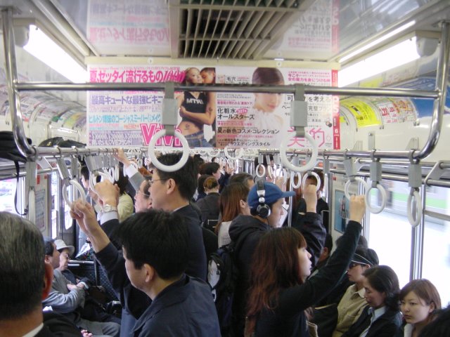 L'interieur du wagon, pas encore bonde, mais rempli de multiples publicites. Tokyo, Japon.