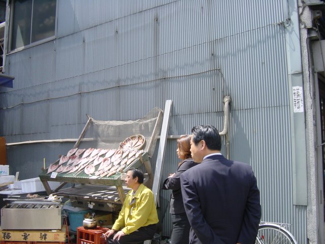 En attente de place. Les poissons sechent au soleil, pendant que d'autres, hors photo, cuisent sur la braise. Tokyo, Japon.