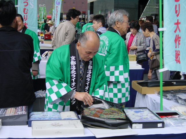 Vendeurs ou demonstrateurs devant la Gare de Kyoto, Japon.